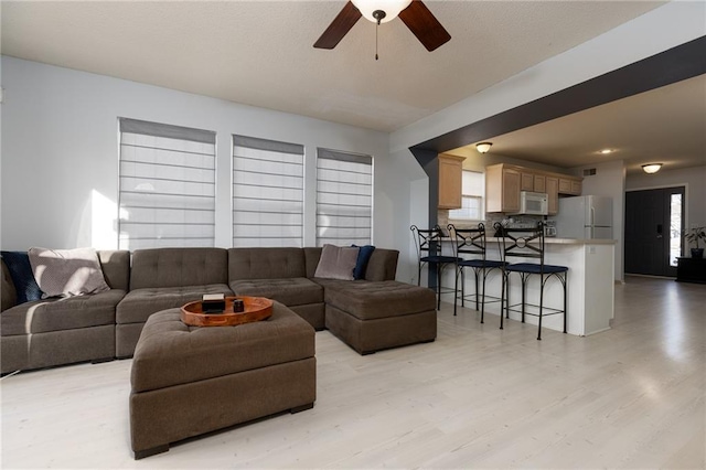 living room featuring ceiling fan and light hardwood / wood-style flooring