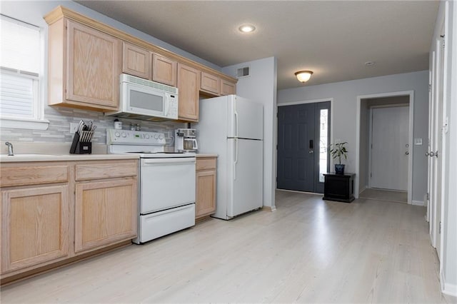 kitchen with sink, white appliances, tasteful backsplash, light brown cabinetry, and light wood-type flooring