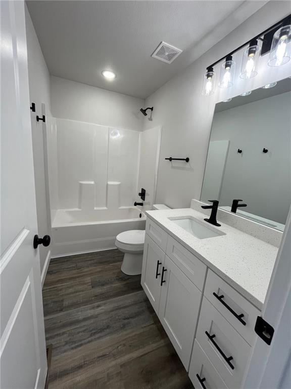 full bathroom featuring toilet,  shower combination, wood-type flooring, and vanity