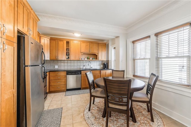 kitchen featuring stainless steel appliances, tasteful backsplash, light tile patterned flooring, crown molding, and sink