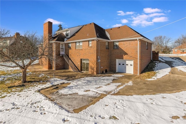 snow covered property with a garage