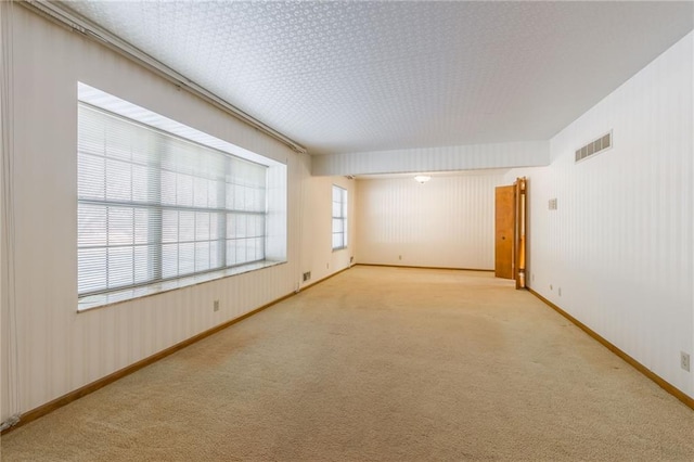 unfurnished room featuring light carpet