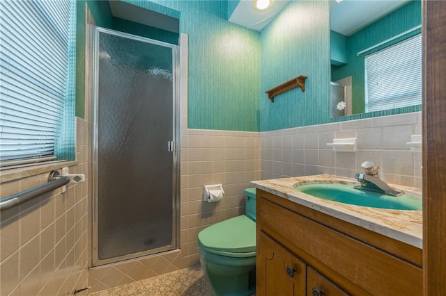 bathroom featuring tile walls, an enclosed shower, vanity, and toilet