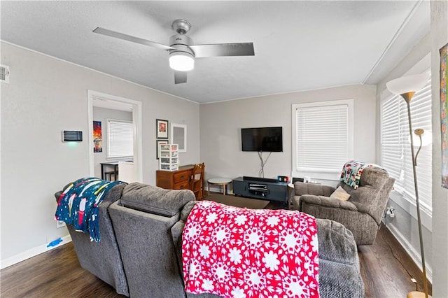 living room featuring dark wood-type flooring and ceiling fan