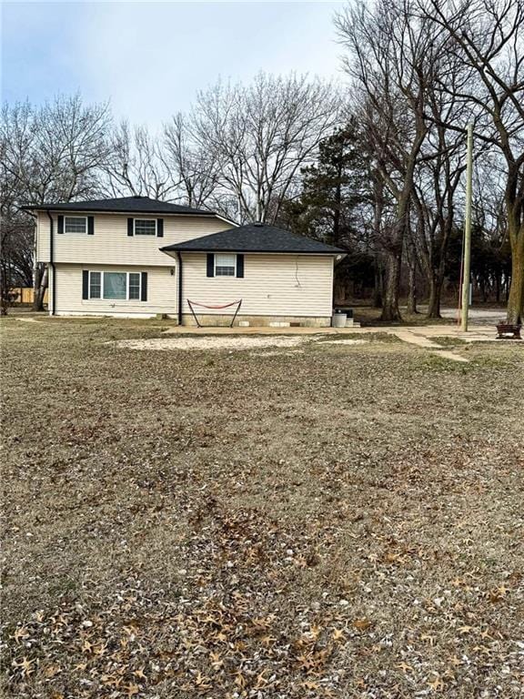 rear view of house featuring a lawn