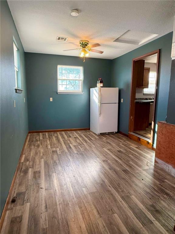 interior space featuring wood-type flooring, a textured ceiling, and ceiling fan