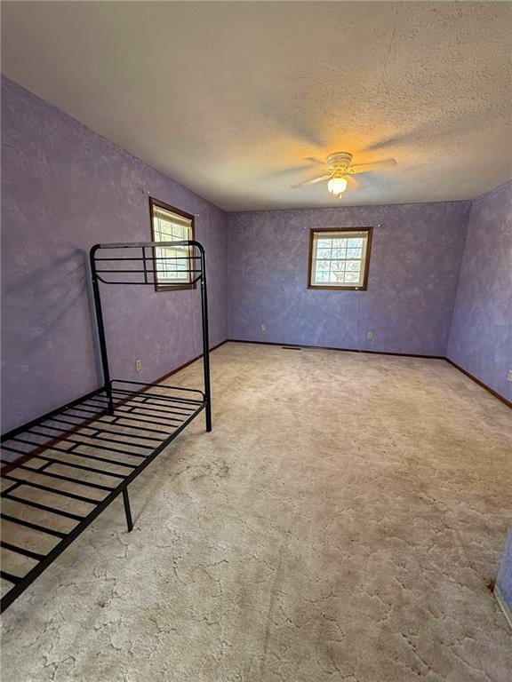 basement with plenty of natural light, carpet, and a textured ceiling