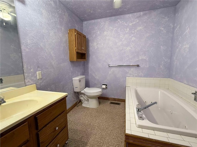 bathroom featuring vanity, tiled tub, and toilet