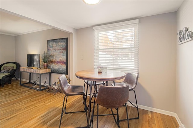 dining room featuring wood-type flooring and crown molding