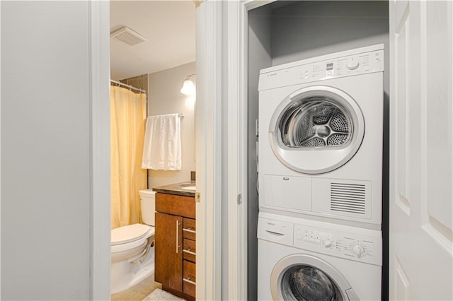 washroom featuring stacked washer and clothes dryer