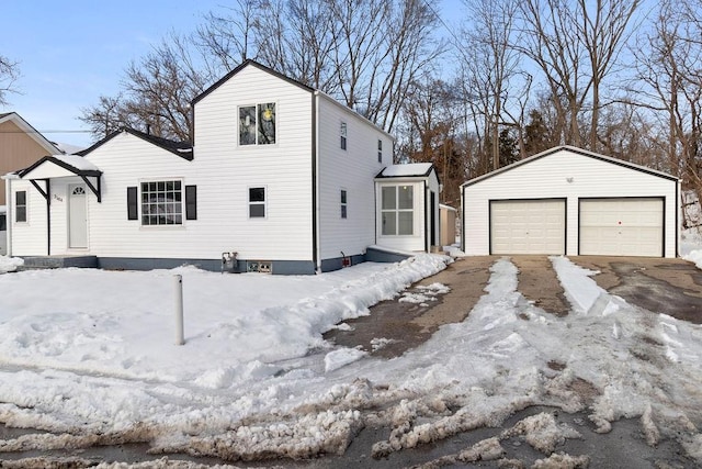 view of snow covered exterior with a garage and an outdoor structure