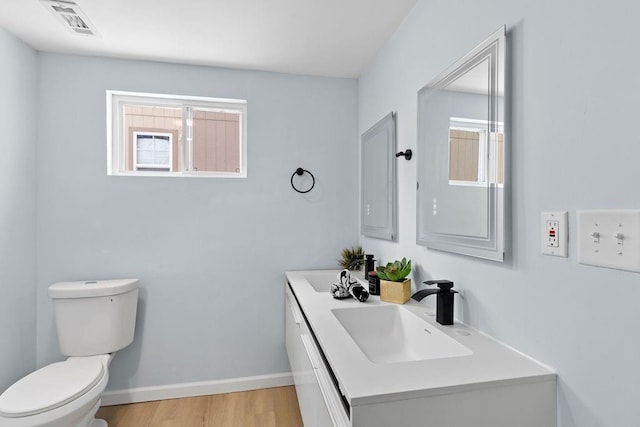 bathroom with toilet, hardwood / wood-style flooring, and vanity