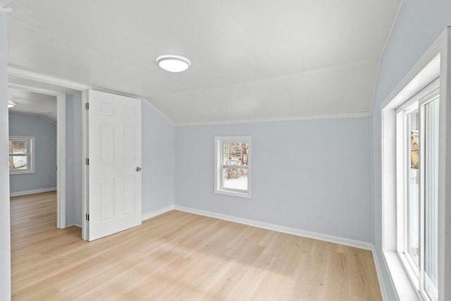 bonus room featuring lofted ceiling, light hardwood / wood-style flooring, and a healthy amount of sunlight