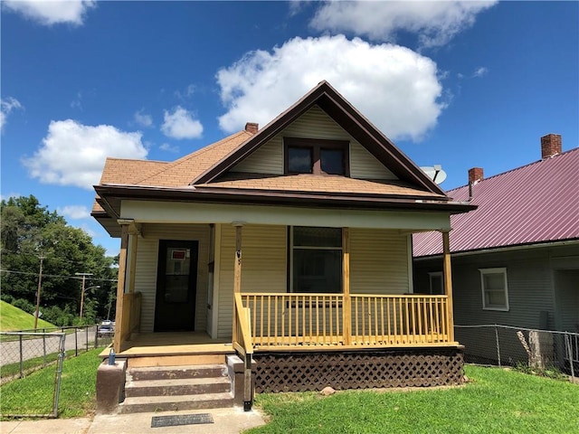 view of front of house featuring covered porch and a front lawn