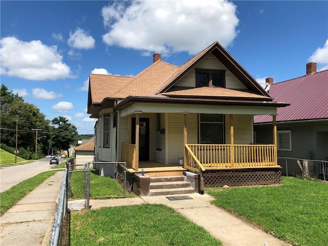 bungalow-style home featuring covered porch and a front lawn