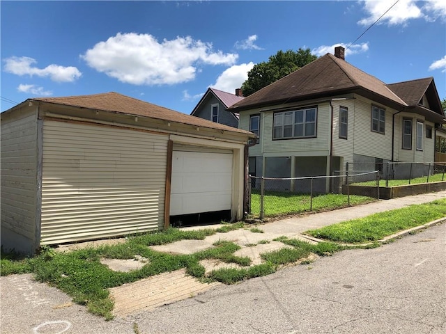 view of property exterior with a garage and an outdoor structure