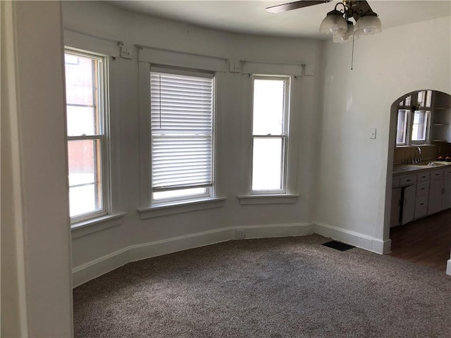 carpeted spare room with ceiling fan and sink