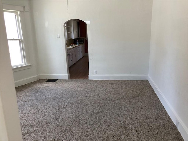 unfurnished room featuring dark colored carpet