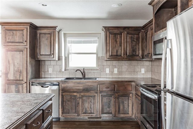 kitchen with backsplash, dark hardwood / wood-style flooring, sink, and stainless steel appliances