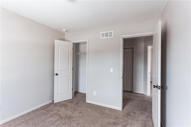 unfurnished bedroom with light carpet and a closet