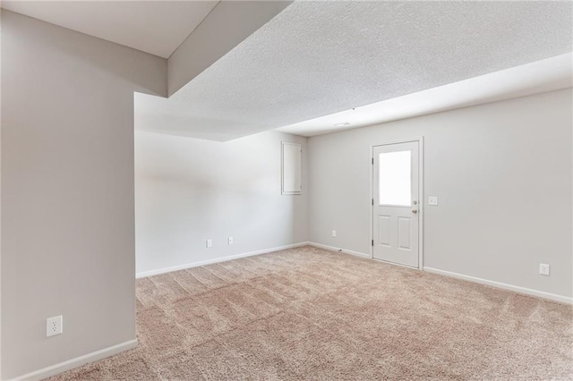 carpeted spare room featuring a textured ceiling