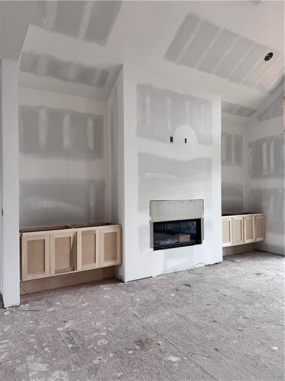 unfurnished living room featuring a glass covered fireplace
