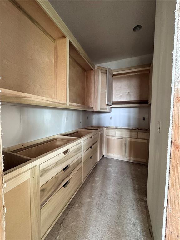kitchen featuring light brown cabinets and concrete flooring