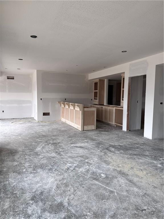 unfurnished living room featuring visible vents and a textured ceiling