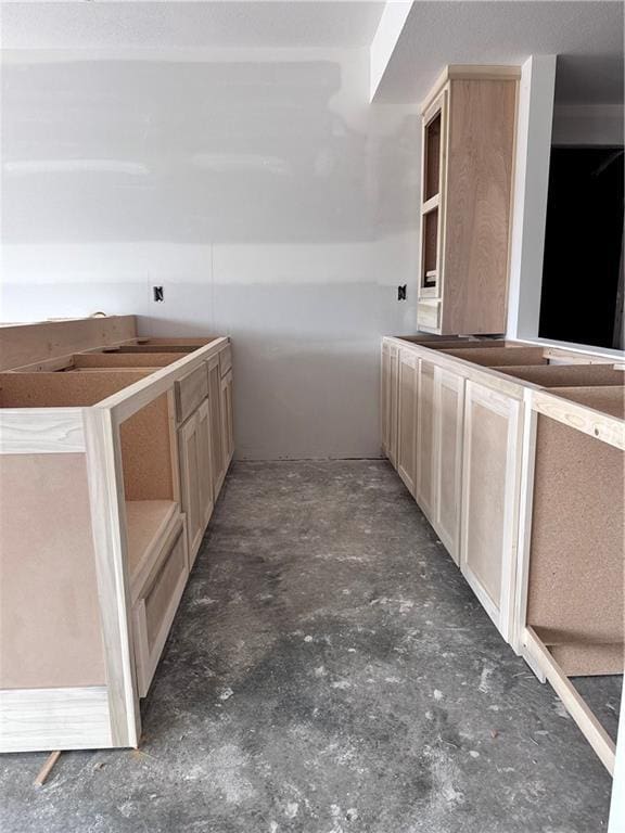 kitchen with unfinished concrete floors and light brown cabinetry