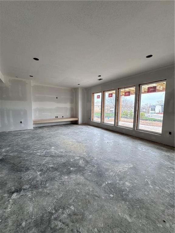 unfurnished living room featuring concrete flooring and a textured ceiling