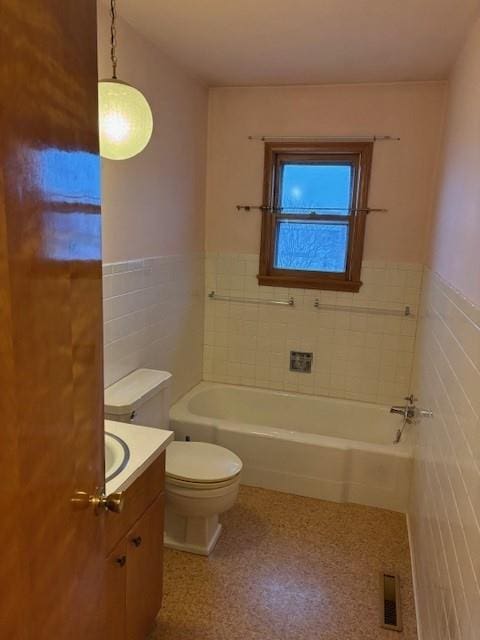 bathroom with toilet, vanity, a bath, and tile walls