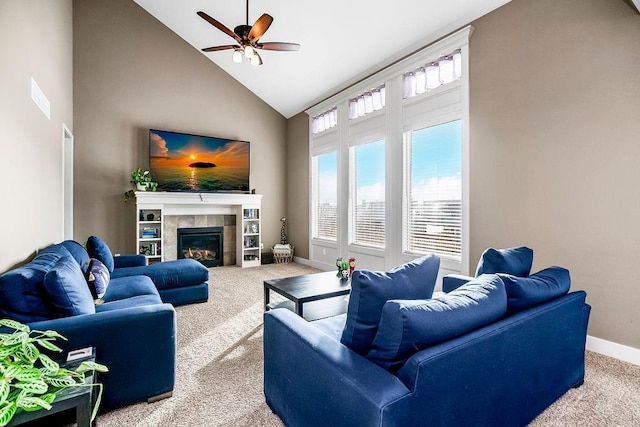 carpeted living room with high vaulted ceiling, a tile fireplace, and ceiling fan