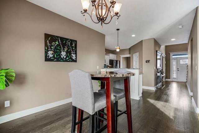 dining area featuring dark hardwood / wood-style flooring and an inviting chandelier