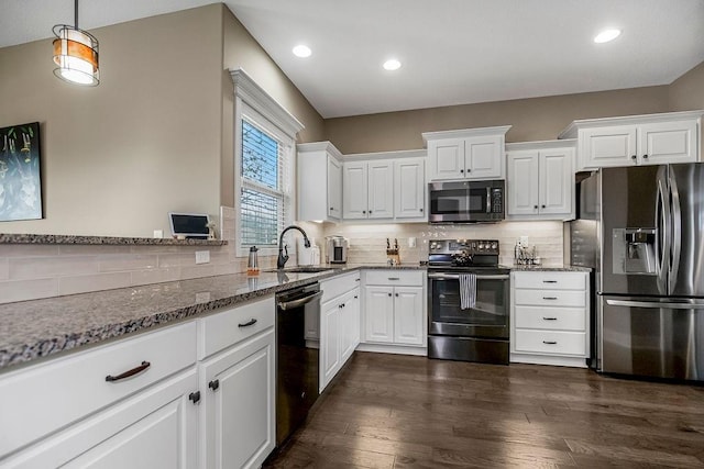 kitchen featuring stainless steel appliances, sink, dark stone countertops, and white cabinets