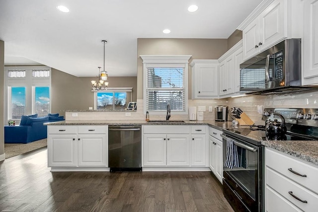 kitchen with black / electric stove, stainless steel dishwasher, sink, and white cabinets