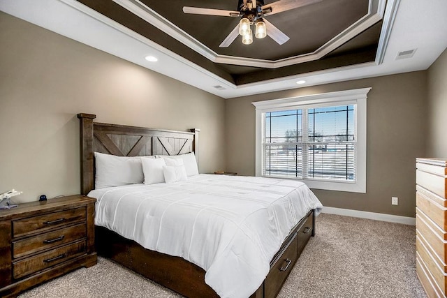 carpeted bedroom with ornamental molding, ceiling fan, and a tray ceiling