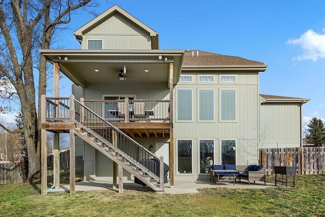 rear view of property with ceiling fan, outdoor lounge area, a patio area, and a lawn