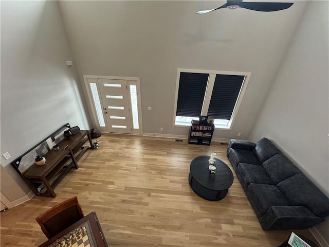 living room with ceiling fan, plenty of natural light, and light hardwood / wood-style flooring