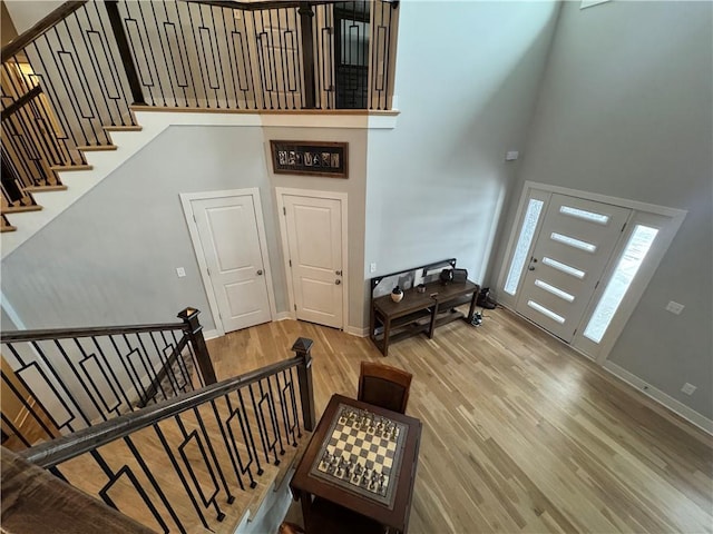 staircase with a high ceiling and wood-type flooring