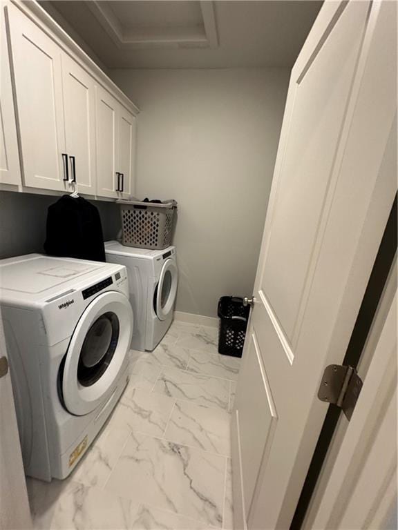 clothes washing area with independent washer and dryer and cabinets