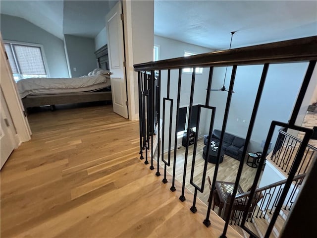 staircase featuring vaulted ceiling and wood-type flooring