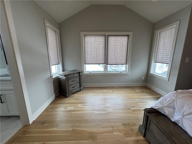 bedroom with vaulted ceiling and light hardwood / wood-style flooring