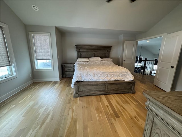 bedroom featuring light hardwood / wood-style flooring and lofted ceiling