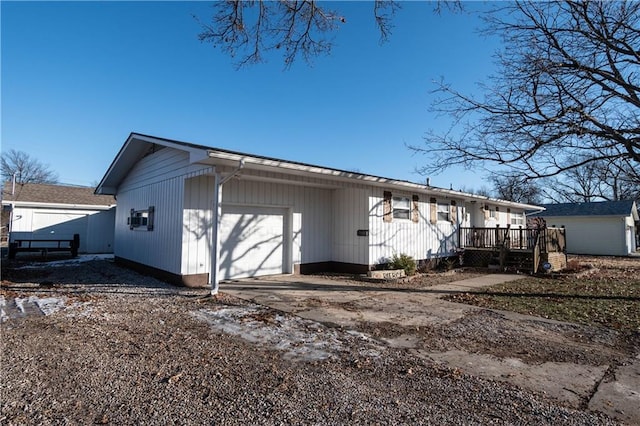 rear view of house with a garage and a wooden deck