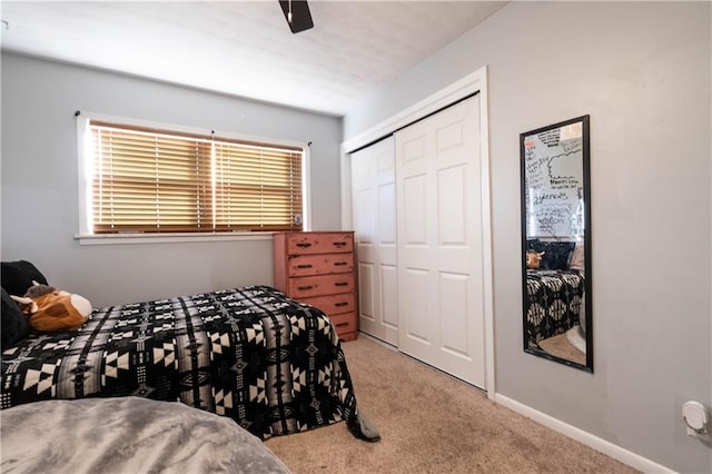 bedroom with ceiling fan, a closet, and light colored carpet