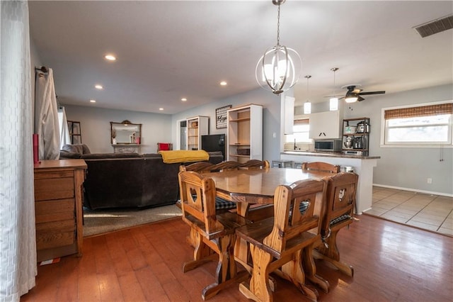 dining space featuring ceiling fan with notable chandelier and hardwood / wood-style floors