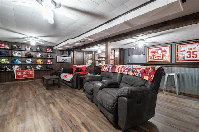 living room with hardwood / wood-style flooring, built in shelves, and wood walls