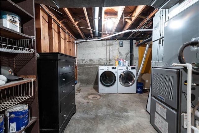 clothes washing area featuring heating unit and washer and clothes dryer