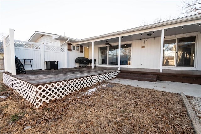 rear view of property featuring ceiling fan and a deck