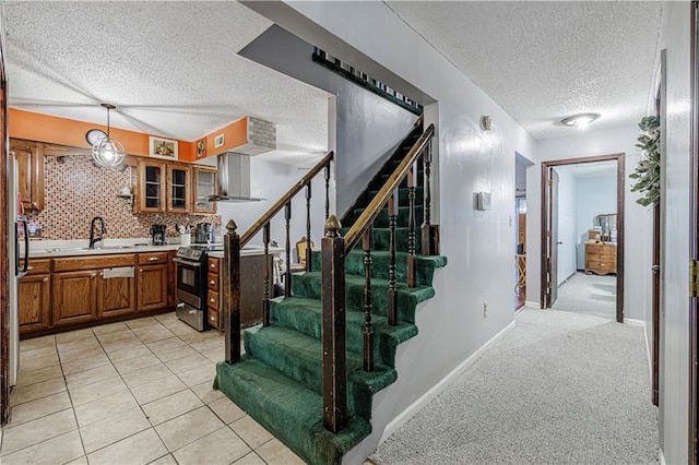 9215 E 85th St, Raytown, MO 64138 - staircase featuring tile patterned flooring, a textured ceiling, baseboards, and carpet floors